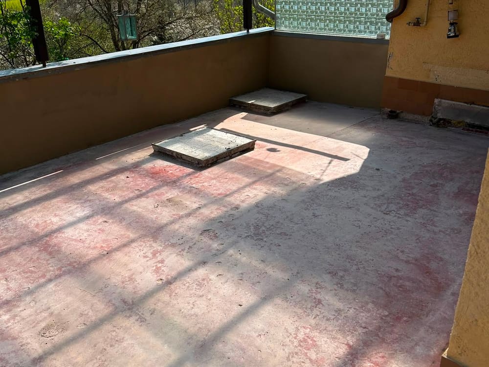 Terrasse vor der Sanierung: alter Belag entfernt, Rohbetonfläche mit Restmörtel sichtbar
